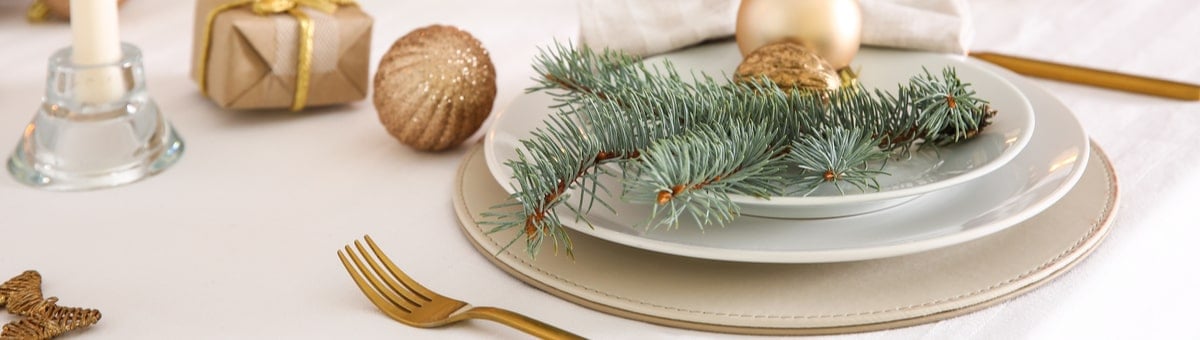 moderns ziemassvetku galds ar baltu galdautu un zelta piederumiem