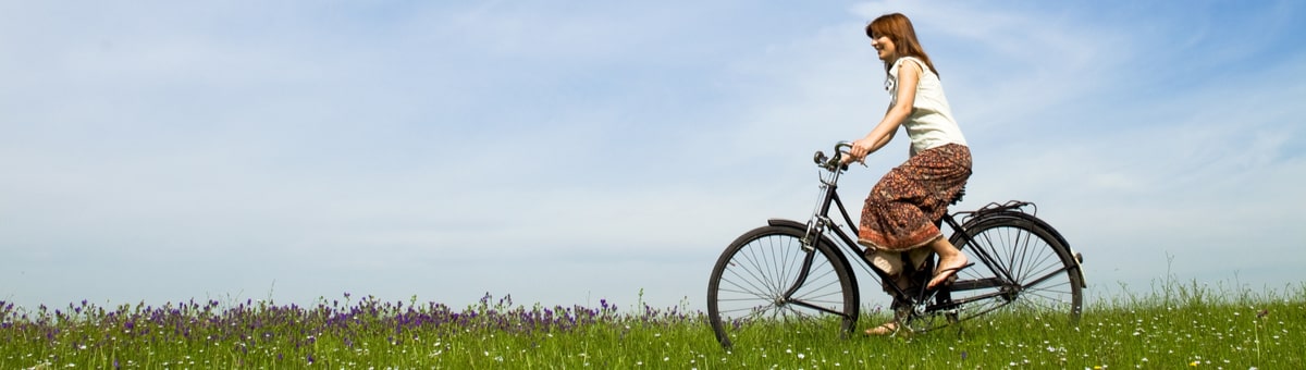 sieviete brauc ar velosipedu pa plavu