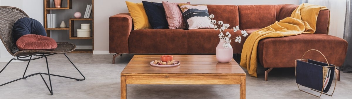 moderns bruns stura divans ar dekorativiem spilveniem